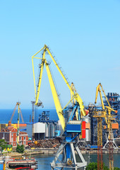 Port cargo crane over blue sky background