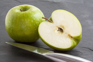 Pommes Granny-Smith et moitié sur fond ardoise