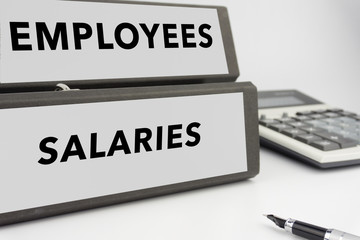 Employees and Salaries - two binders on white background with calculator and pen