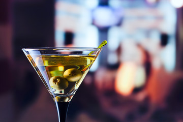 glass with martini and green olives