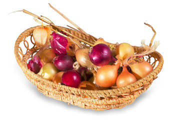 Bunch of beige and purple onions in wicker basket