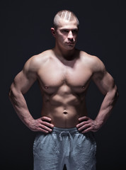 Fototapeta na wymiar sportsman with muscular torso in dark space