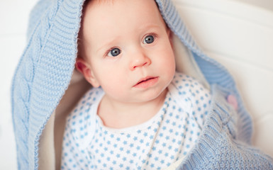 Cute baby boy with knitted blanket on. Childhood. 