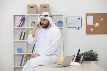 Young Arabic business man Talking on phone in his office