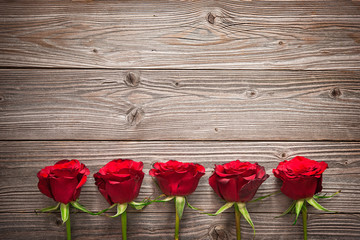Obraz na płótnie Canvas Red roses on wooden board