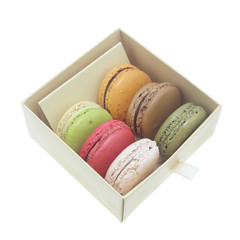 Tasty colorful macaroon in box paper on white background