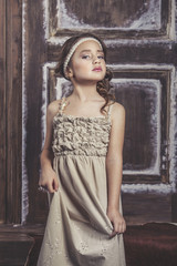 Fototapeta premium Little girl beautiful fashion in gentle natural dress on a back