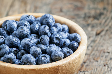 Wet blueberries in bowl, selective focus