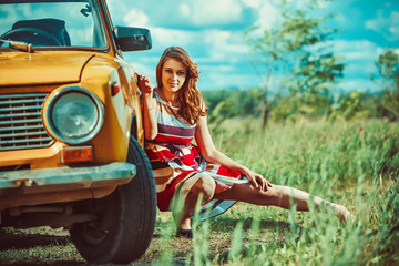 Beautiful woman near the old car