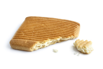 Single square Italian shortbread honey and milk biscuit with ridges, isolated on white in perspective. Broken with crumbs.