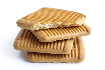 Pile of four square Italian shortbread honey and milk biscuits with ridges, isolated on white in perspective. One broken.