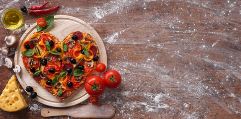 Pizza hart vorm met ingrediënten en kopieer spase op vintage achtergrond. Fijne Valentijnsdag. liefde concept