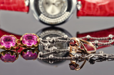 Gold earrings and rings with red rubies and watch