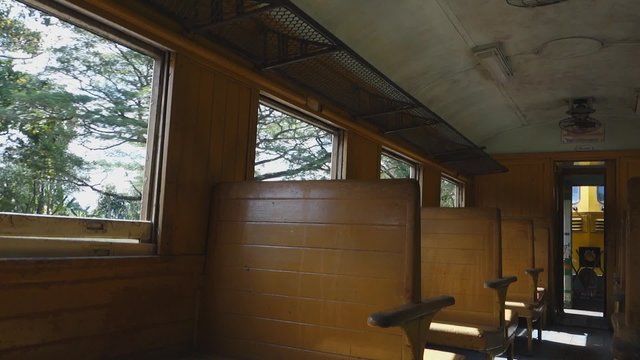 Man traveler in a old train passenger carriage with wooden bench seat, Thailand, Southeast Asia