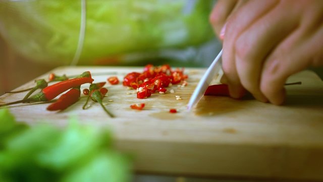 Man Cutting Chili on Cutting Board with Ceramic White Knife - Color Graded Close Up 60 fps