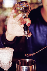 Bartender is adding bitter to shaker, toned
