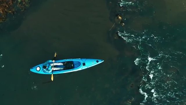 Man kayaking on the forest river. HD aerial shot. GoPro edited footage, slow motion 50 FPS.