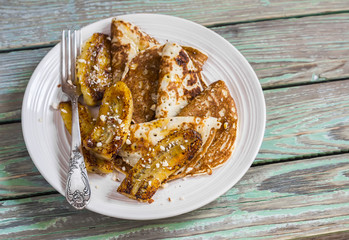 Fried bananas and pancakes with honey and almonds. Tasty breakfast, snack or dessert. On a wooden rustic background