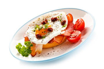 Breakfast - breadroll, fried egg, bacon and vegetables 