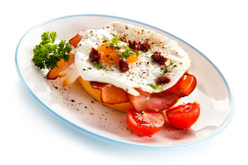 Breakfast - breadroll, fried egg, bacon and vegetables 