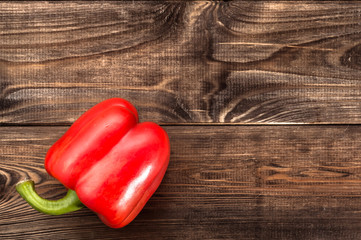 Red paprika on rustic wooden background.