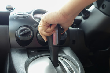 woman holding gear in car.