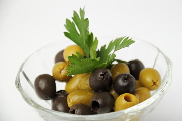 Olives. / Olives with parsley in a glass container.
