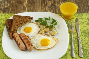 Breakfast with fried eggs, sausage, marinade mushrooms and bread