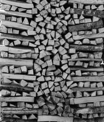 chopped firewood kiln and stacked in the woodpile. copy space. Free space for text. black and white photo