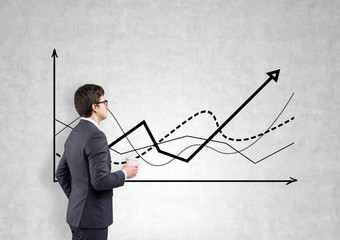 A businessman studying graphs