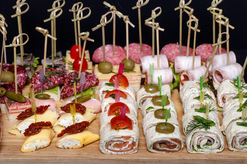 Different kinds of snacks canape on skewers. Selective focus