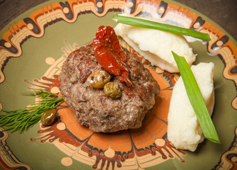 Homemade cutlet with mashed potatoes on a plate on old wooden ta