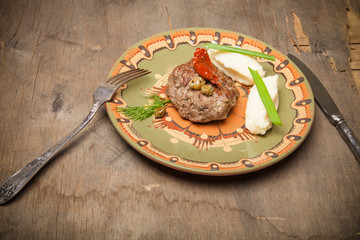 Homemade cutlet with mashed potatoes on a plate on old wooden ta