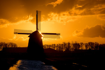 backlit Dutch windmill during sunrise