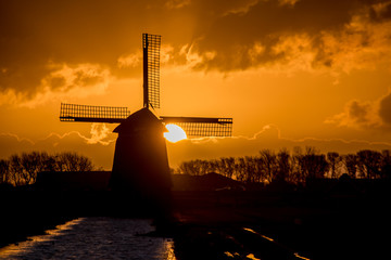 backlit Dutch windmill during sunrise
