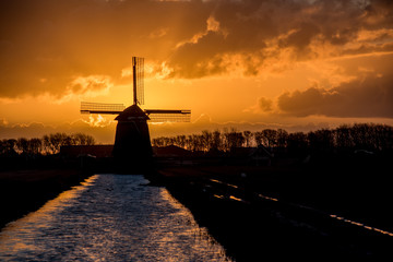 backlit Dutch windmill during sunrise