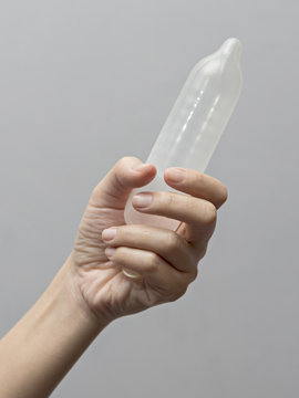 Female hand holding condom