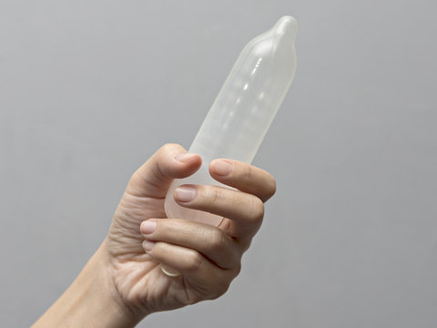 Female hand holding condom