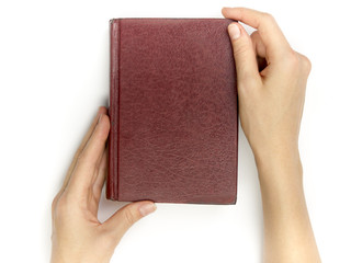 Hands hold blank red hardcover book on white background