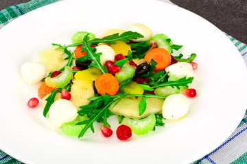 Dietary delicious salad on white plate of arugula, pear, walnut,