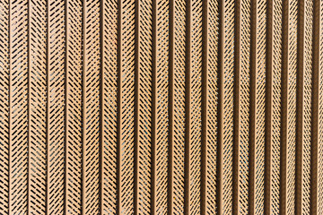 a metal pattern on a fence construction covering a wall