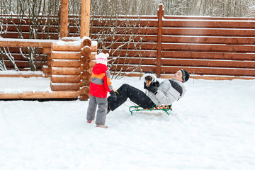 Dad daughter and dog sledding in backyard