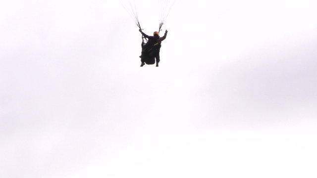 Experience the thrill of a tandem paragliding flight with a skilled pilot and passenger controlling the paraglide after takeoff.