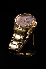 Gold watch on a plastic background