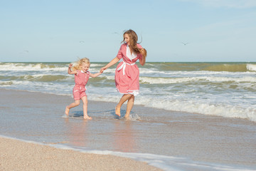 Mother and her daughter  having fun playing on the beach