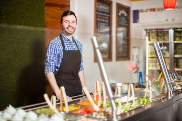 Attractive man working at a salad bar