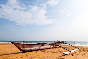 Ein Katamaran liegt am Strand des Indischen Ozeans auf der traumhaften Tropeninsel Sri Lanka