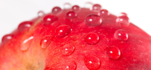 Part of red apple with water drops on a white background