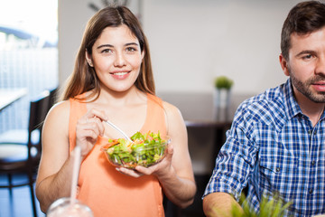 Pretty girl eating salad with friends