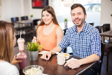 Attractive man eating with some friends